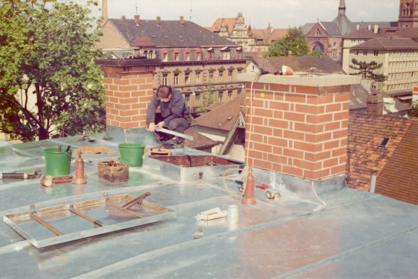 Spenglerarbeiten an Kaminen auf einem Dach mit Blick auf das Freiburger Münster