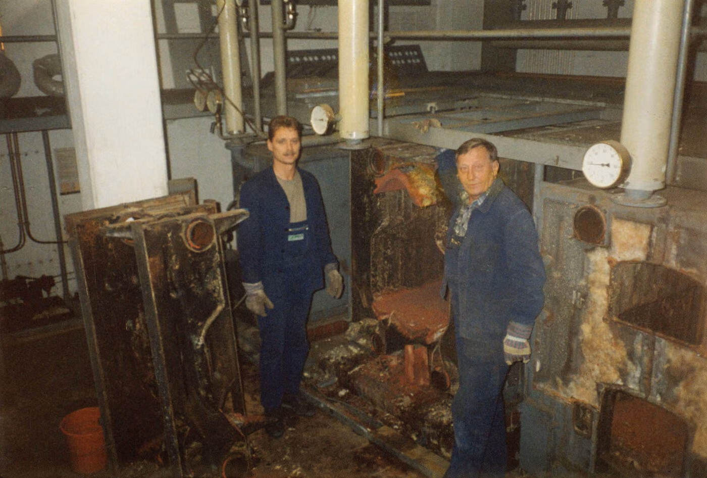 Handwerker bei der Sanierung einer alten Heizungsanlage im Heizraum